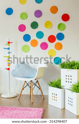 White chair and color spots on wall in child\'s room