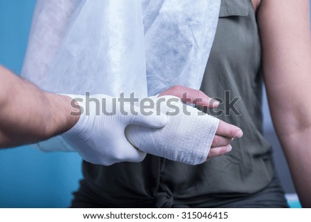 Close-up of woman with bandaged hand and sling