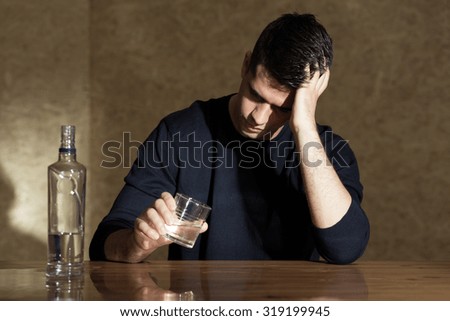Young man drinking vodka in the glass
