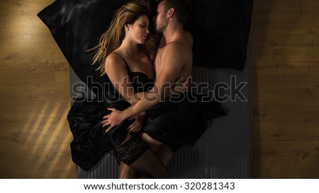 Passionate couple is cuddling after making love