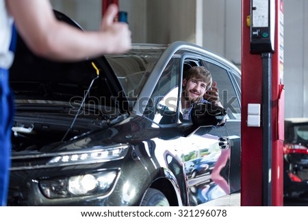 Picture of happy driver in auto repair shop
