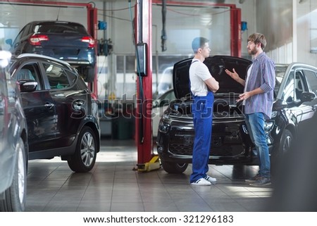 Photo of client discussing with worker of service station