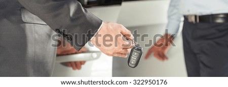Close-up of man in suit with car keys in hand