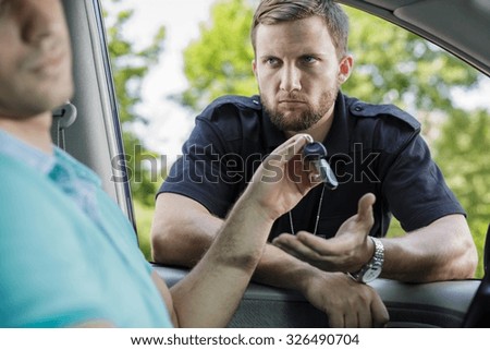 Drunk driver giving back the keys to the police officer