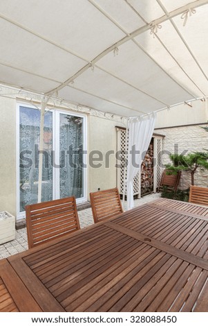 Photo of covered patio with wood garden furniture