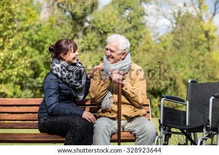 Elder man and carer in the park