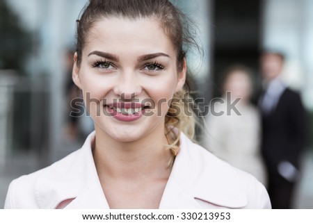 Young woman is smiling outside corporate office