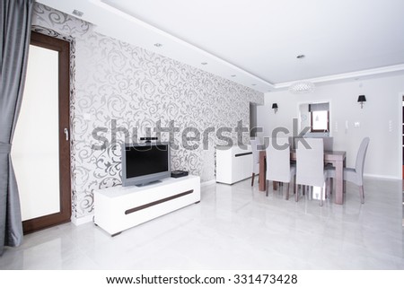 Contemporary spacious white living room with patterned wallpaper