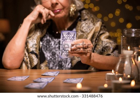 Female seer telling fortune from tarot cards