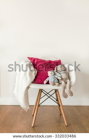 Image of white baby blanket and toy on chair