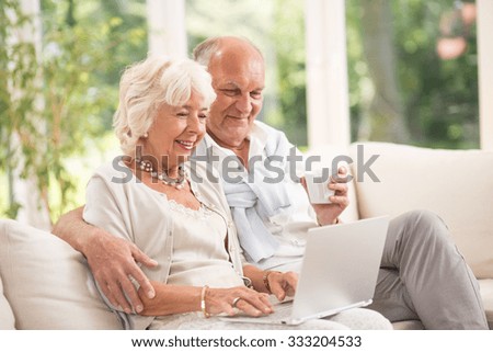 Photo of happy senior pair with computer skills