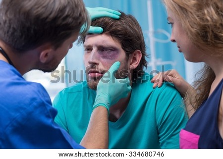 Image of doctor examining patient with black eye