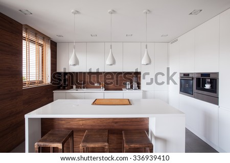 White kitchen island in modern and wooden kitchen