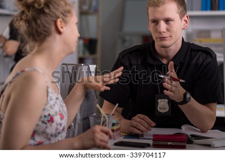 Police officer interrogating woman at police station