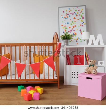 Photo of stylish room for babygirl with wooden crib