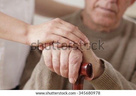 Young woman and old man holding hands