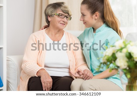 Young caregiver providing care and support in rest home