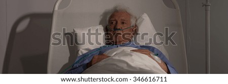 Older patient lying in bed and feeling lonely in hospital