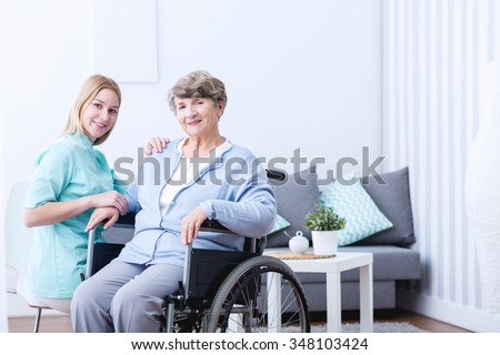 Photo of elderly woman with disability and caregiver