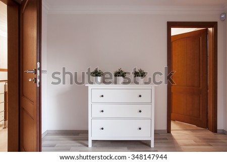 White and wooden chest of drawers in a hallway