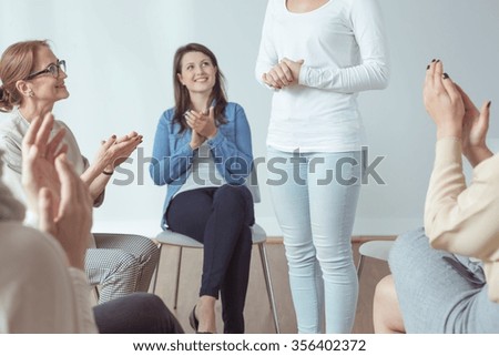 Support group and psychotherapist applauding for friend