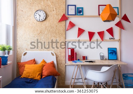 Photo of single bed with decorative cushions in teenager room