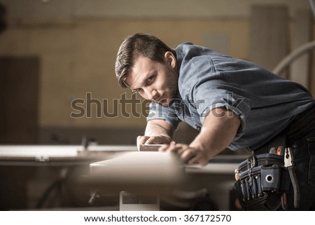 Photo of male wood expert checking quality of board