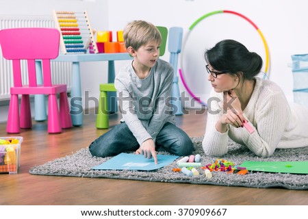 Private teacher and small boy learning by play at home