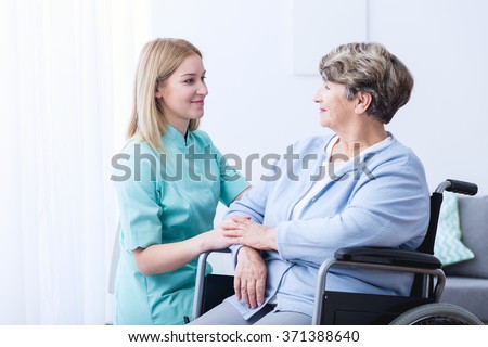 Nurse caring about elder woman at home