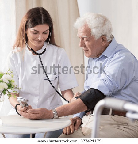 Young nurse is taking elder man\'s blood