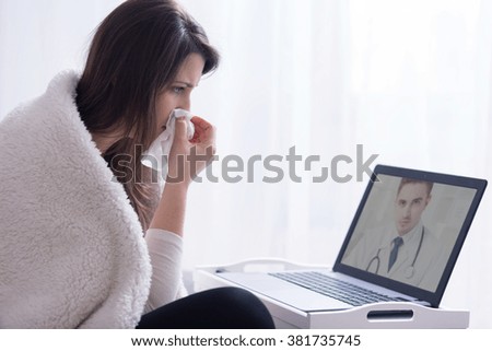 Woman holding hanky during consultation with skype doctor