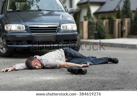 Pedestrian hit by a car lying on the street