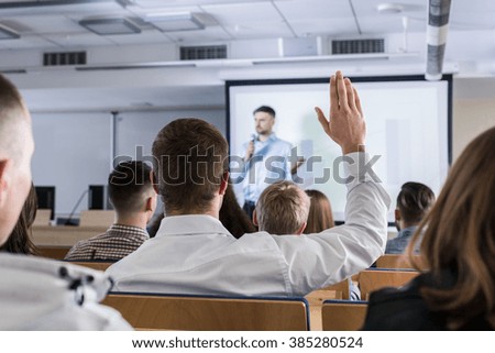 Student raising hand during lecture