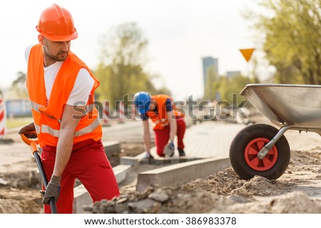Image of strong construction worker digging the ground