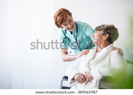 Photo of positive doctor and patient on wheelchair