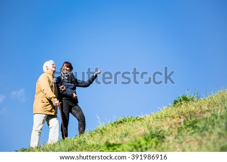 Picture of elderly man relaxing in nature with helpful carer