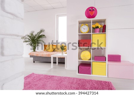 Shot of a white studio apartment with pink and yellow details