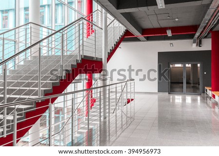 Modern, light staircase with silver railing, red details and black ceiling