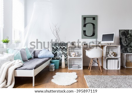 Cozy modern bedroom with hipster design. Single bed and wooden desk in room with wooden floor