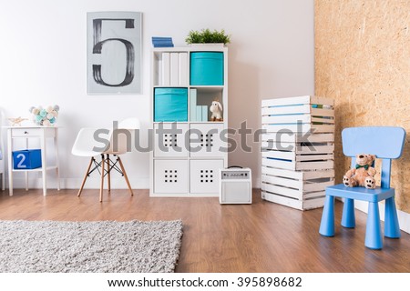 Up-to-date decor of child\'s room with wooden parquet and white furniture