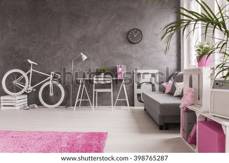 Spacious interior in grey and white with white bike, simple desk, chair and  sofa