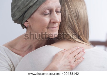 Sick woman with cancer hugging her young daughter
