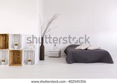 White, spacious bedroom with large bed, handmade nightstand and regale
