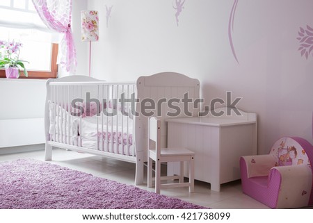 Interior of white and rose baby room