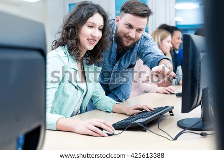 Shot of a young teacher helping an IT student with her work