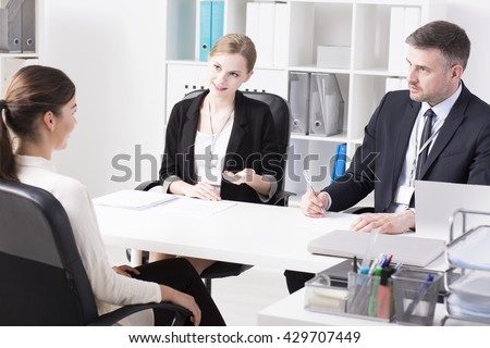 Tow businesspeople and young woman during job interview, sitting in light office