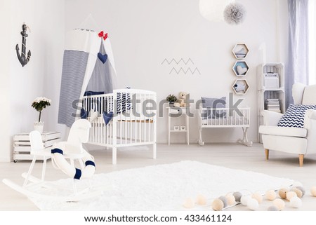 Spacious baby room with simple white furniture and beautiful marine decorations