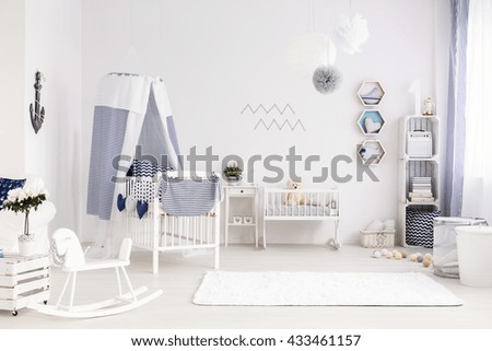 White and spacious baby room with decorations in marine style