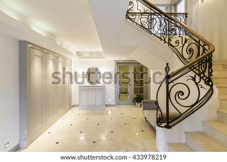 Light and spacious hallway with staircase with decorative railing