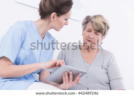 Shot of a young doctor holding a tablet and talking to her patient